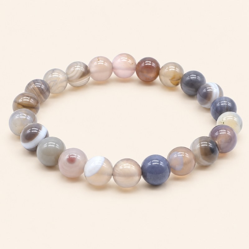 Bracelet en agate Botswana à perles rondes de 8 mm, aux nuances grises, beiges et rosées, sur fond blanc.