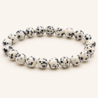 Bracelet en jaspe dalmatien à perles rondes de 8 mm, crème tachetées de noir, présenté sur fond beige clair.