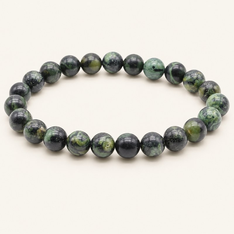 Bracelet en jaspe Kambaba à perles rondes de 8 mm, aux motifs verts et noirs, présenté sur fond beige clair. Bracelet en jaspe Kambaba à perles rondes de 8 mm, aux motifs verts et noirs, présenté sur fond beige clair.