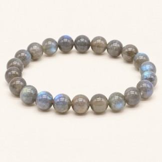 Bracelet en labradorite à perles rondes de 8 mm, grises avec des reflets bleutés et verdâtres, présenté sur fond beige clair.