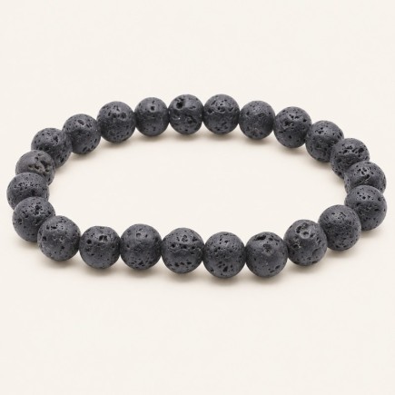 Bracelet en pierre de lave à perles rondes de 8 mm, gris anthracite à noires et poreuses, présenté sur fond beige clair.