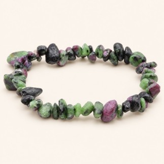 Bracelet baroque en rubis-zoïsite aux pierres polies vertes, noires et rose violacé, présenté sur fond beige clair.
