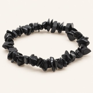 Bracelet baroque en tourmaline noire aux pierres polies de formes irrégulières, présenté sur fond beige clair.