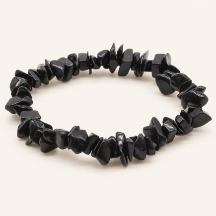Bracelet baroque en tourmaline noire aux pierres polies de formes irrégulières, présenté sur fond beige clair.