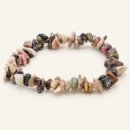 Bracelet baroque en rhodonite aux pierres polies rosées, crème, beiges et sombres, présenté sur fond beige clair.