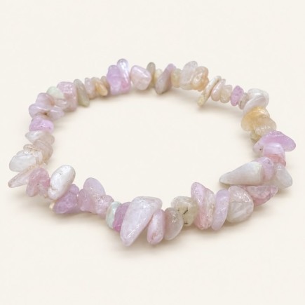 Bracelet baroque en kunzite aux pierres polies rose pâle, lilas, blanchâtres et crème, présenté sur fond beige clair.