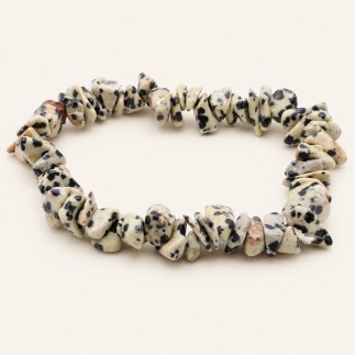 Bracelet baroque en jaspe dalmatien aux pierres polies crème et beige tachetées de noir, présenté sur fond beige clair.