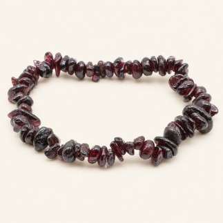 Bracelet baroque en grenat aux pierres chips rouge sombre et bordeaux, présenté sur fond beige.