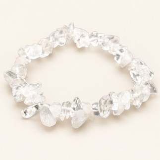 Bracelet baroque en cristal de roche aux pierres chips transparentes et voilées, présenté sur fond beige.