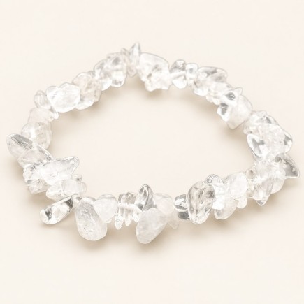 Bracelet baroque en cristal de roche aux pierres chips transparentes et voilées, présenté sur fond beige.