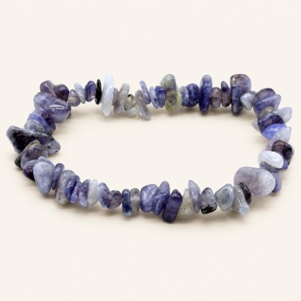 Bracelet baroque en cordiérite aux pierres chips bleu violet et gris bleuté, présenté sur fond beige.