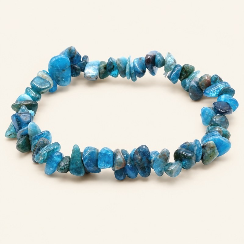 Bracelet baroque en apatite aux pierres chips bleu turquoise et bleu-vert, présenté sur fond beige.