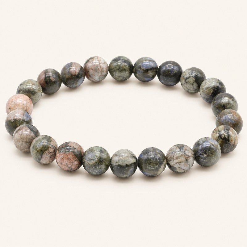 Bracelet en libérite du Hunan, Chine, avec perles rondes de 8 mm aux nuances gris-vert, crème et rosées, sur fond beige.