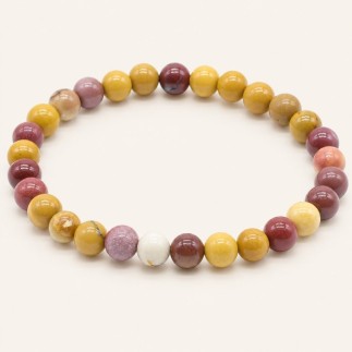 Bracelet en jaspe mokaïte, perles rondes de 8 mm aux nuances jaune ocre, bordeaux, rose et crème, sur fond beige.